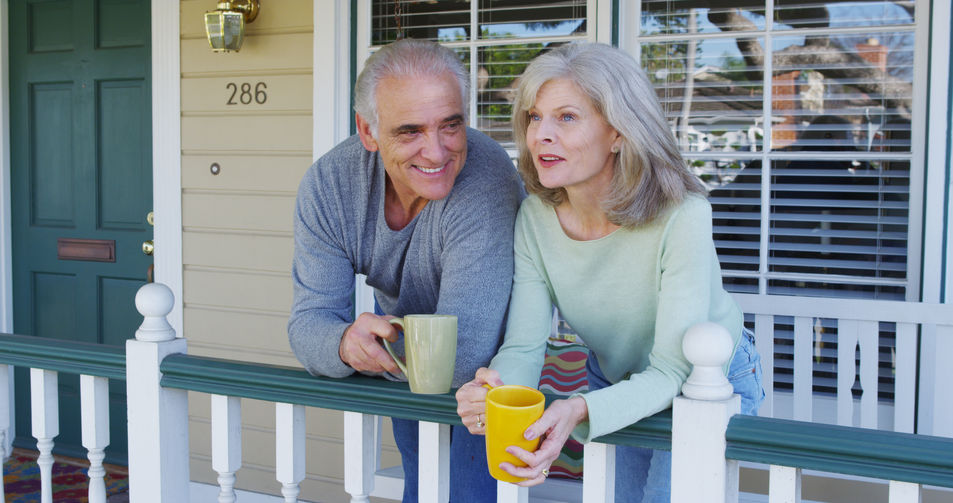 Senior couple drinking coffee on their home front porch image